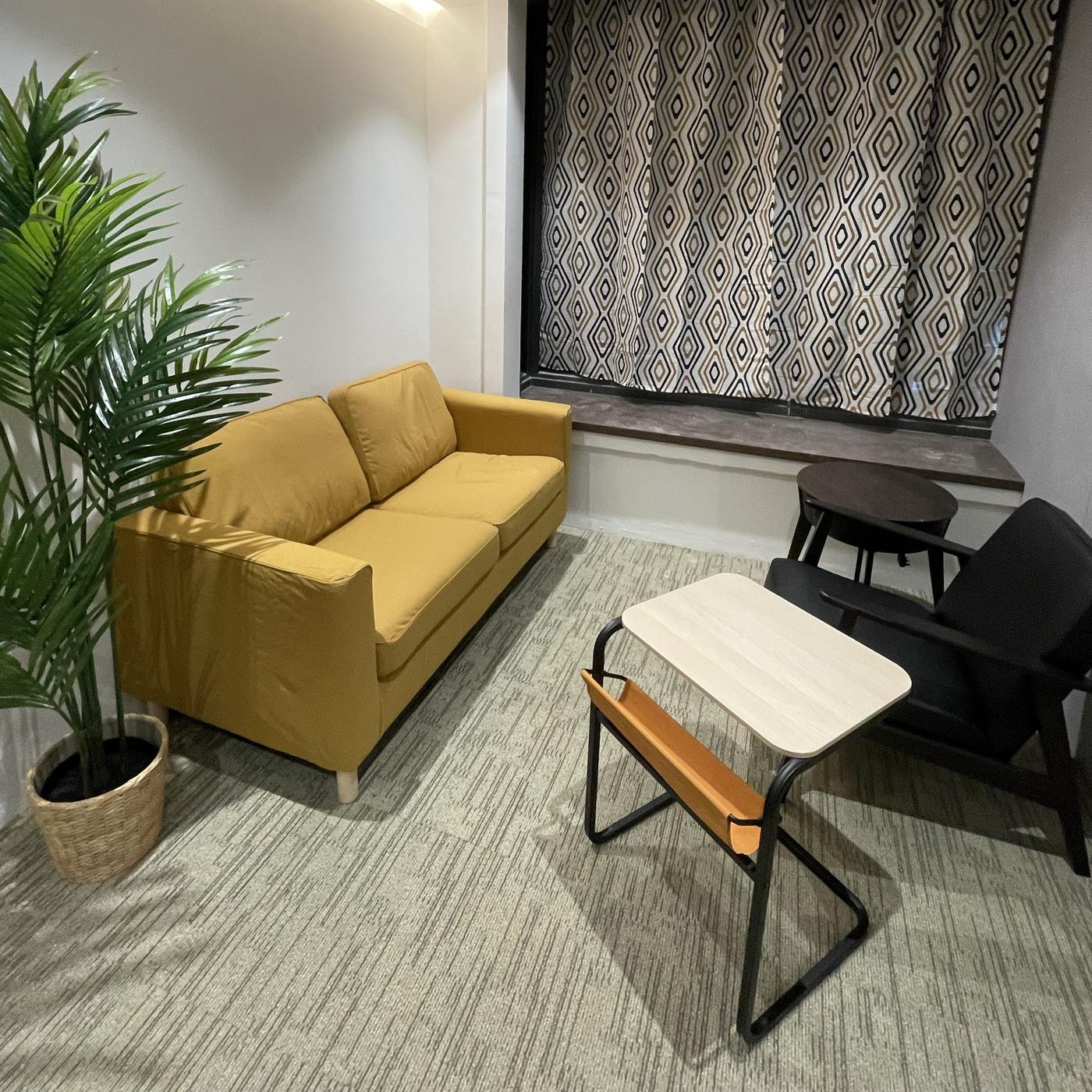 Image of a plant and a yellow 2-seater sofa with OLSEROD side table in a cosy lounge/meeting room in Singapore, designed by IKEA for Business: Business Interior Design Service