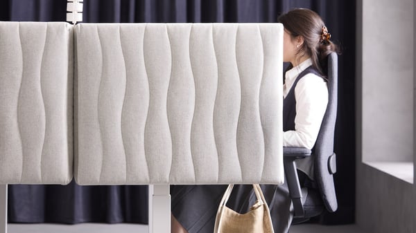 image of a woman sitting behind a desk divider