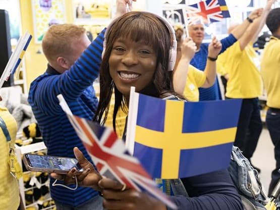 Image of IKEA Co-worker smiling and holding British and Swedish flags