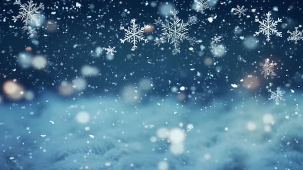 Image of snowflakes falling with a blurred blue background