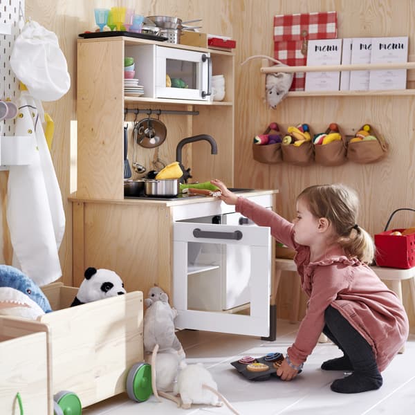 Imagen acercada de cocina DUKTIG con peluches de la misma serie.