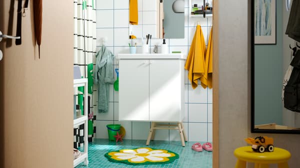 Imagen de baño con mueble blanco con piso celeste.