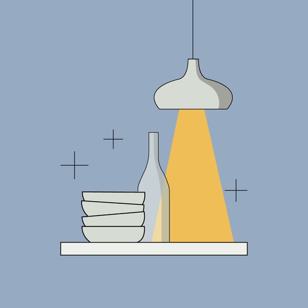 Imagen de unos platos con luz y una botella sobre una repisa blanca.