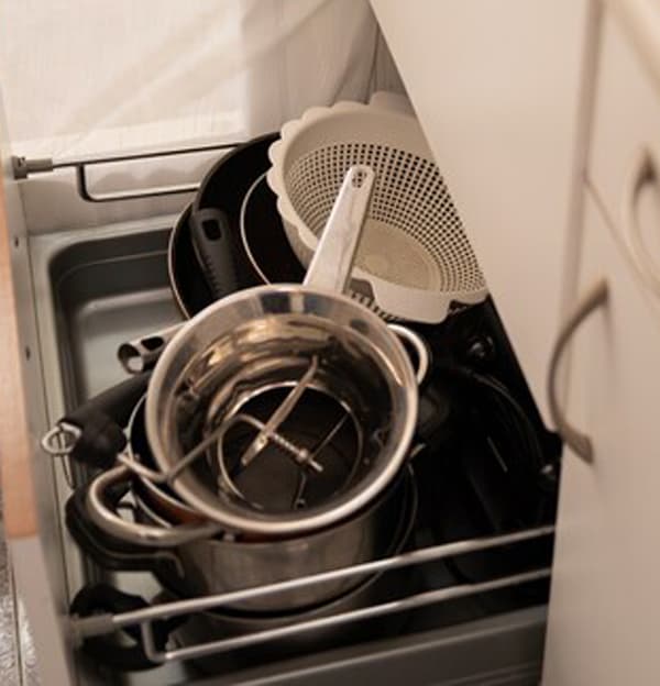 Imagen del interior del cajón de la cocina de Feli desorganizado.
