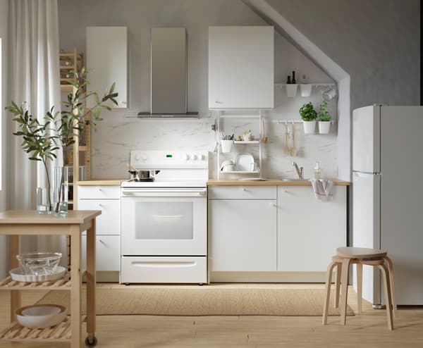 Imagen frontal de una cocina con muebles blancos y beige.