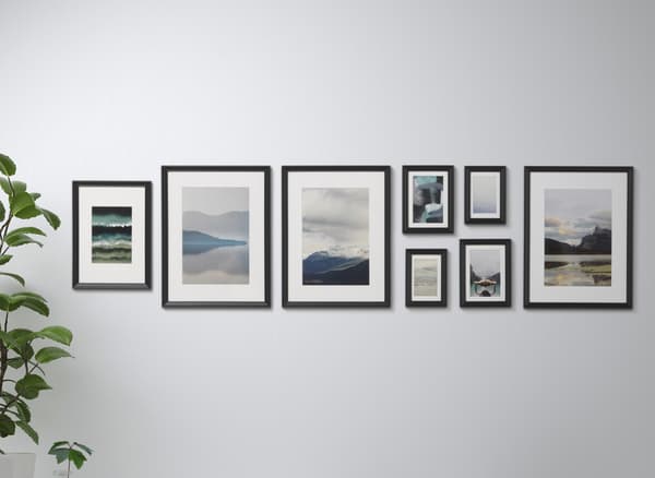 Images dans des cadres noirs, sur un mur blanc.