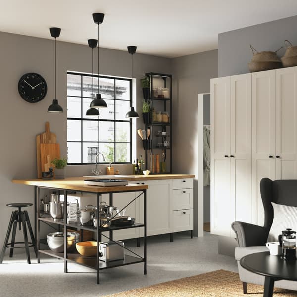Immagine di una cucina di colore bianco con bancone in stile industriale e luci a sospensione nere.