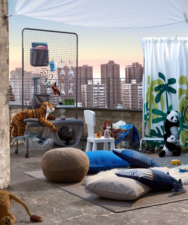 Improvizált gyerekszínház a tetőn. Szőnyegek és díszpárnák, mint ülőhelyek; puha játékok, színpad és VEBERÖD állvány.