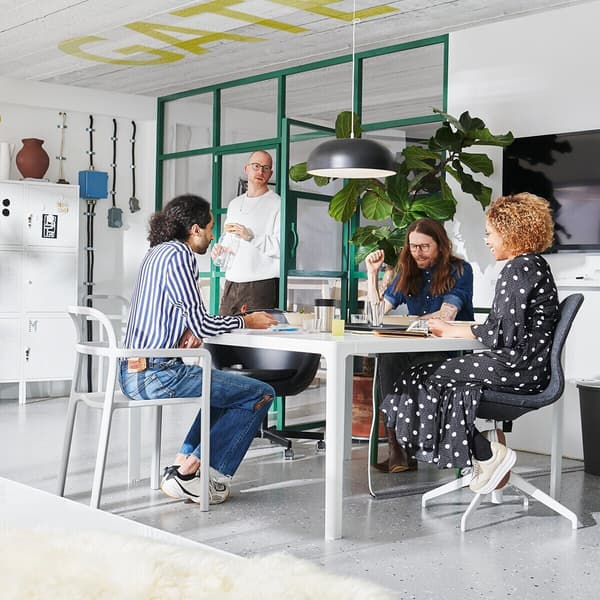 In a conference room, employees sit at a table during a meeting