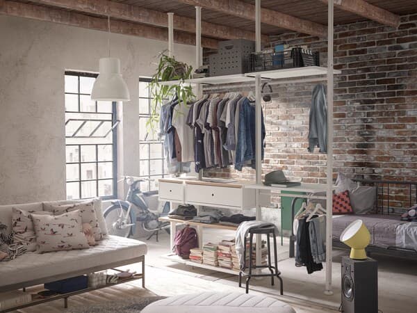 In a rustic room there is an open ELVARLI wardrobe system.