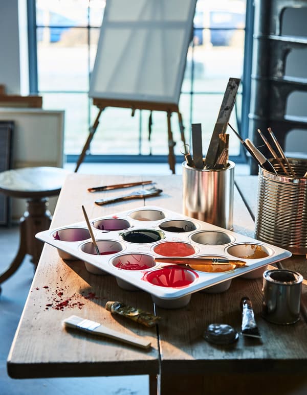 In an artist’s studio, a muffin tin is used as a paint pallet.