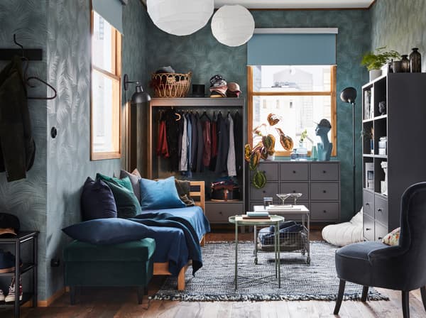 In deze kleine moderne studio staan de kast, de garderobekast en het ladeblok verspreid tegen verschillende muren om de ruimte een luchtigere aanblik te geven.