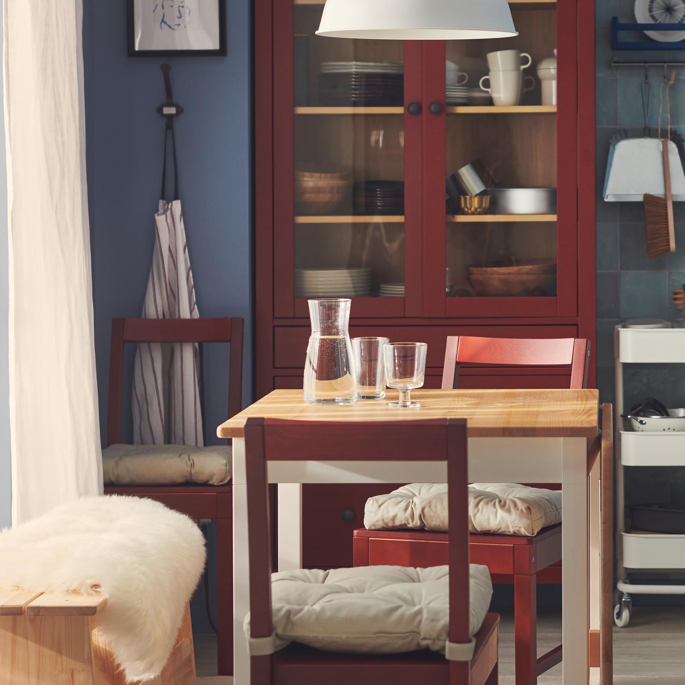 In een eetkamer in Zweedse cottagestijl met blauw getegelde muren staat in het midden een PINNTORP klaptafel met stoelen.