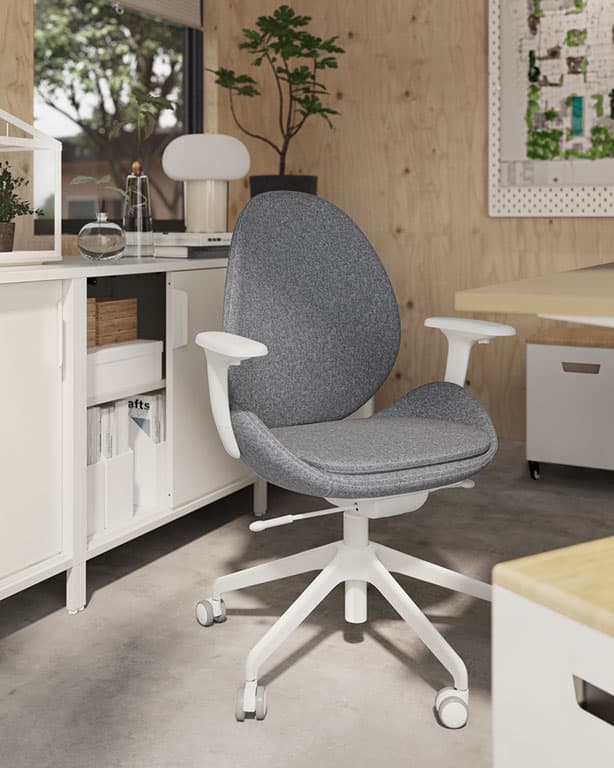 In einem sonnigen Büro mit Wänden mit heller Holzverkleidung ist ein HATTEFJÄLL Drehstuhl mit Armlehnen in Mittelgrau umgeben von Aufbewahrungsmöbeln zu sehen. 