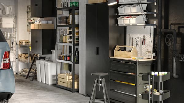 In un garage, mobili a giorno e con ante BROR. Sui ripiani ci sono scatole e bottiglie. Sotto ci sono i contenitori per la raccolta differenziata - IKEA.