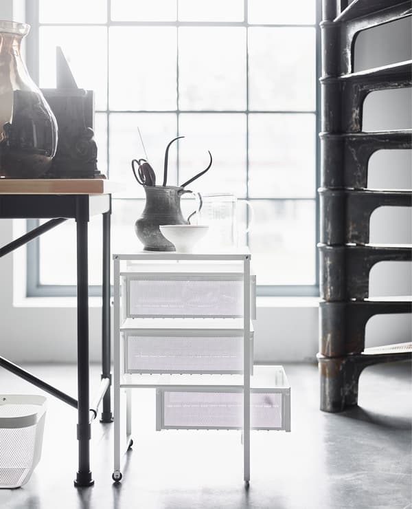 Industrial furniture combined with lighter pieces like a white mesh drawer unit creates softness and freshness.
