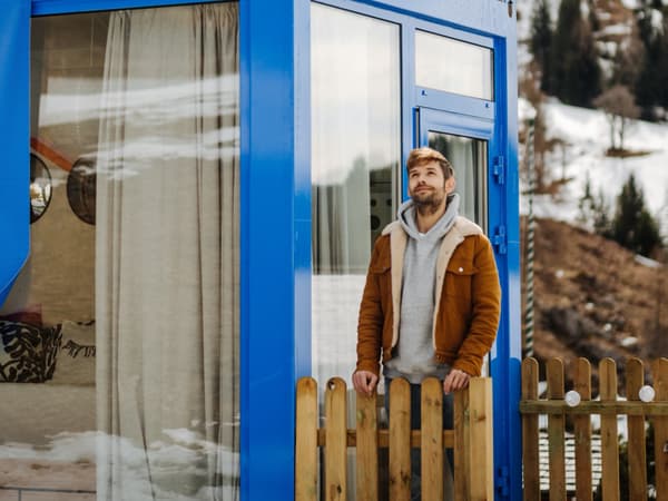 Influencer Michael Buchinger steht vor der blauen Schlummertasche und sieht in die Ferne.