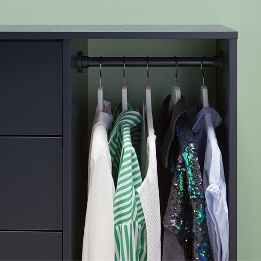 Ingek lógnak egy sínen, egy fekete-kék tárolóelemben.