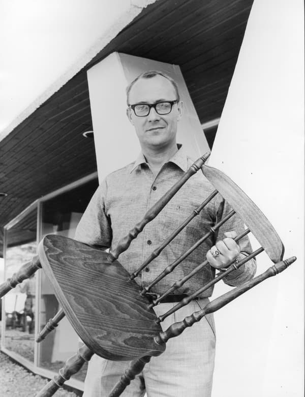 Ingvar Kamprad håller en pinnstol på ett svartvitt foto.