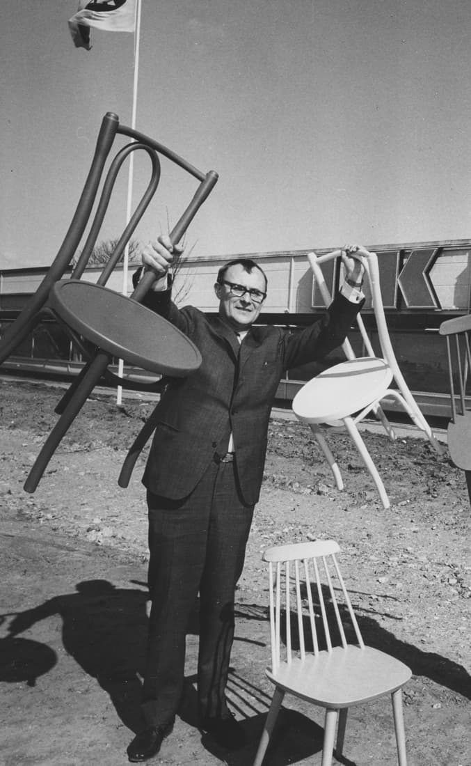 Ingvar Kamprad holding up two dining chairs