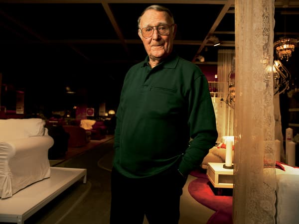Ingvar Kamprad steht in einem IKEA Einrichtungshaus und trägt einen dunkelgrünen Pullover.