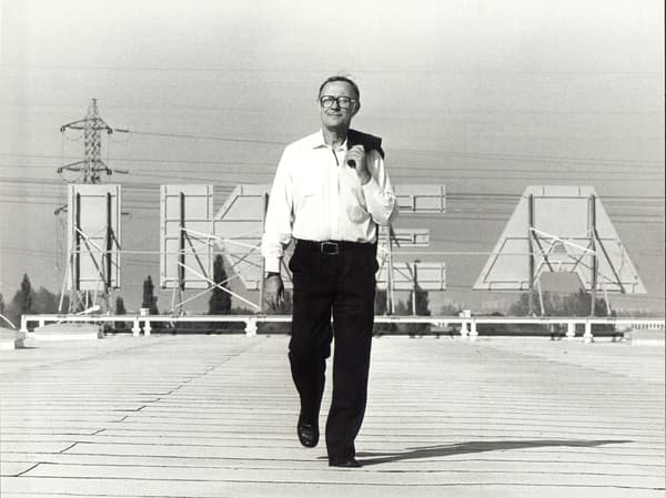 Ingvar Kamprad walking past IKEA board