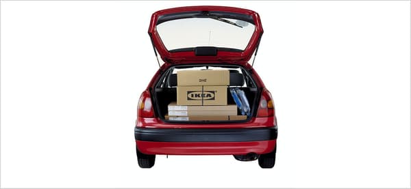 赤い車のトランクに荷物が載っている。