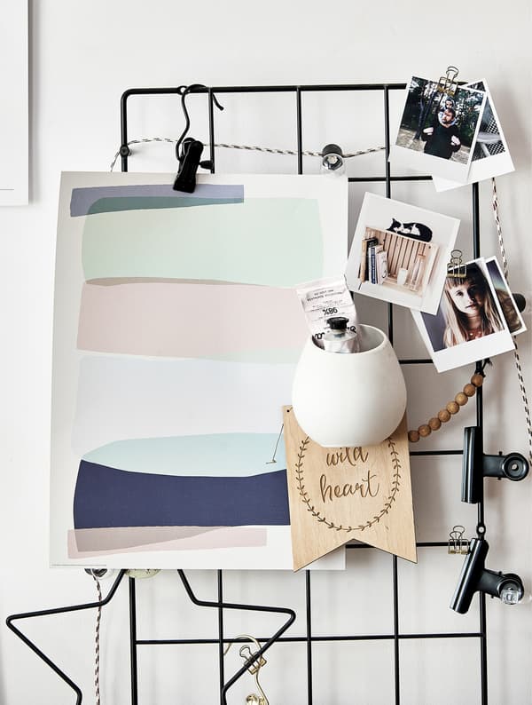 Inspiration et photos clipsées sur un cadre en métal accroché au mur.