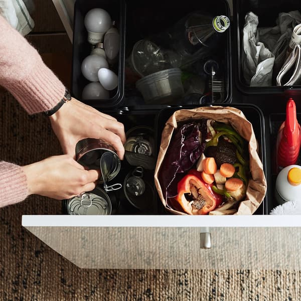 Intérieur d'un tiroir de cuisine contenant des poubelles VARIERA remplies de déchets domestiques soigneusement triés.