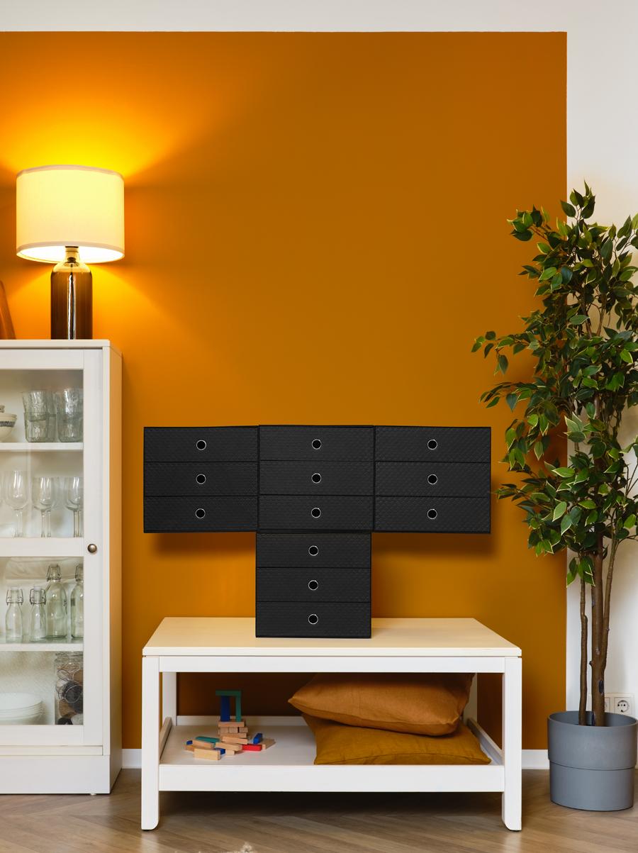  interieurhoek met gele muur en zwarte miniladekast