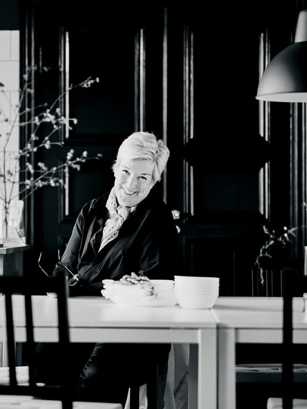 Interior designer Mia Gustafsson sitting at a dining area formed by two MELLTORP tables and STEFAN chairs.