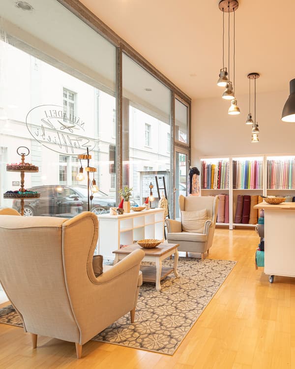 Interior view of a fabric shop with seating area and shelves with go.ods