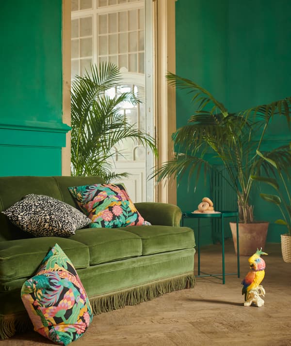 Interno elegante sui toni del verde. Divano GRIMHILD con cuscini NÄBBFLY, con accanto delle piante.