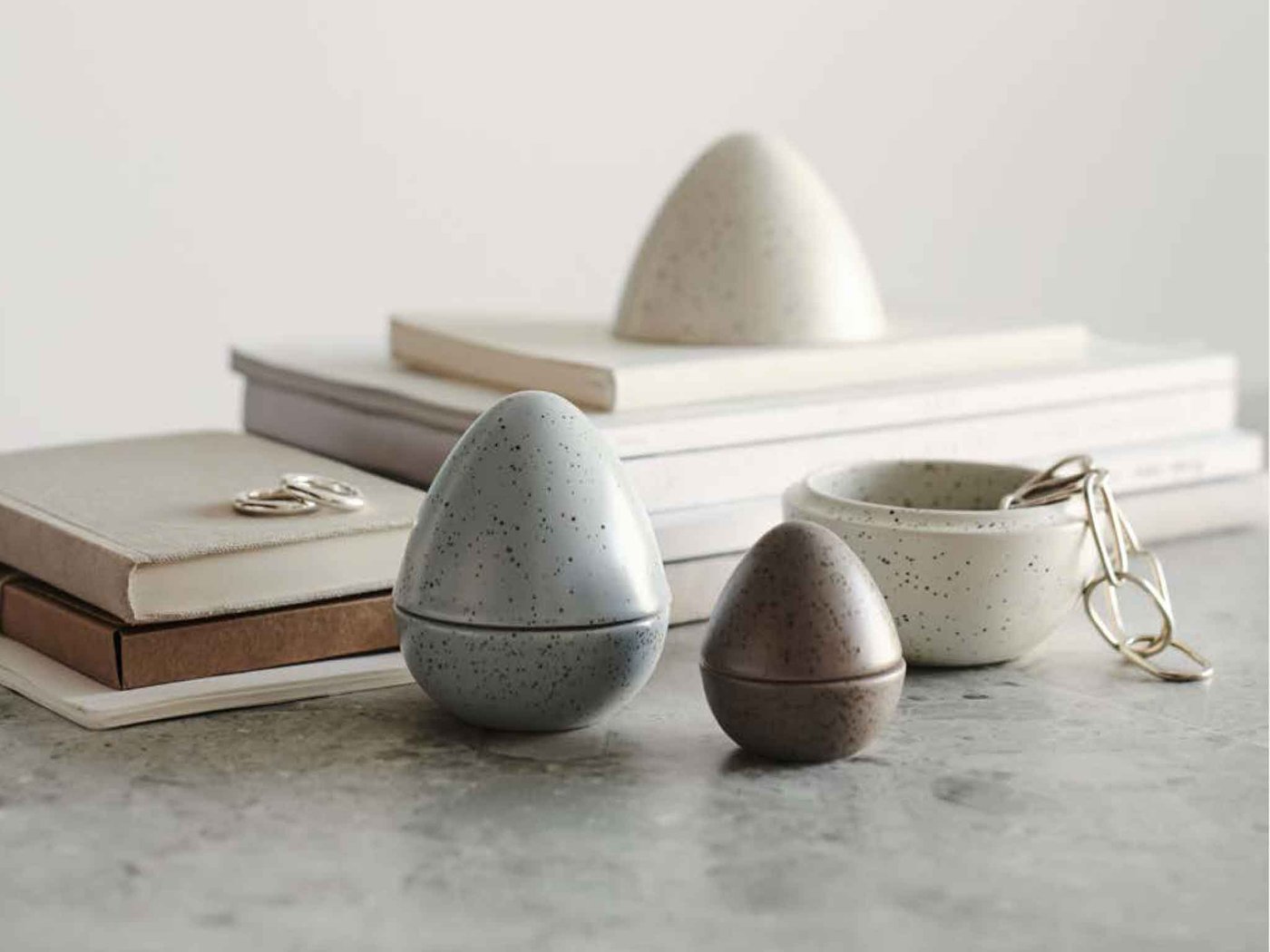 Items from the RÅDFRÅGA Decorations, set of 3 collection, displayed near stacked books with a beige background.