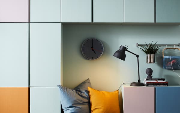 IVAR cabinets painted in various pastel colours against a pale green wall.
