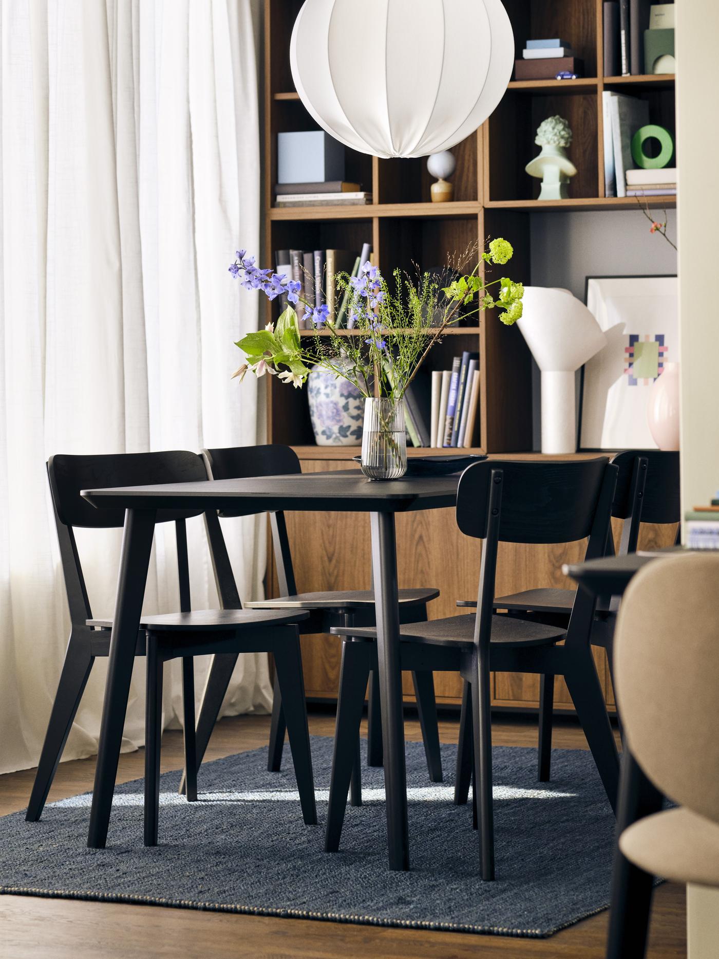 Jadalnia ze stołem i krzesłami LISABO, lampą wiszącą nad stołem i niebieskim dywanem LANDBANA na podłodze.