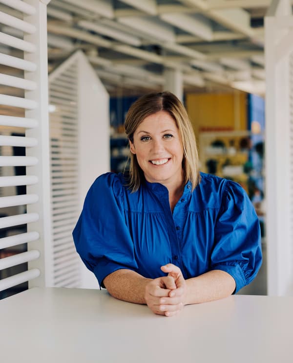 Janie Bisset, CEO d’IKEA Suisse, se tient debout, souriante, près d'une table dans un bureau.
