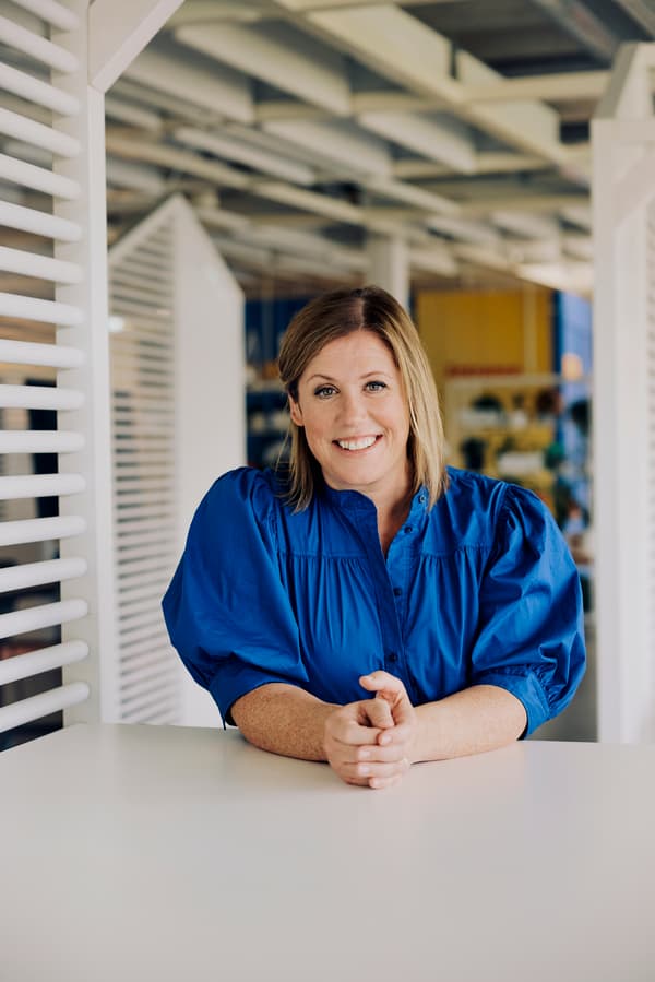 Janie Bisset, CEO von IKEA Schweiz, steht lächelnd an einem Tisch im Büro.