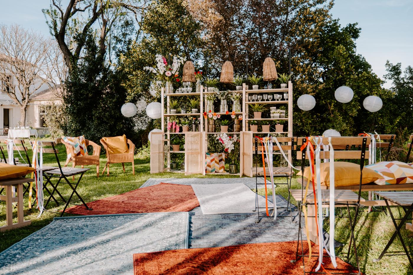 jardin décoré pour la midsommar avec des tapis colorés, de chaises pliables et une grande armoire remplie de décoration variée