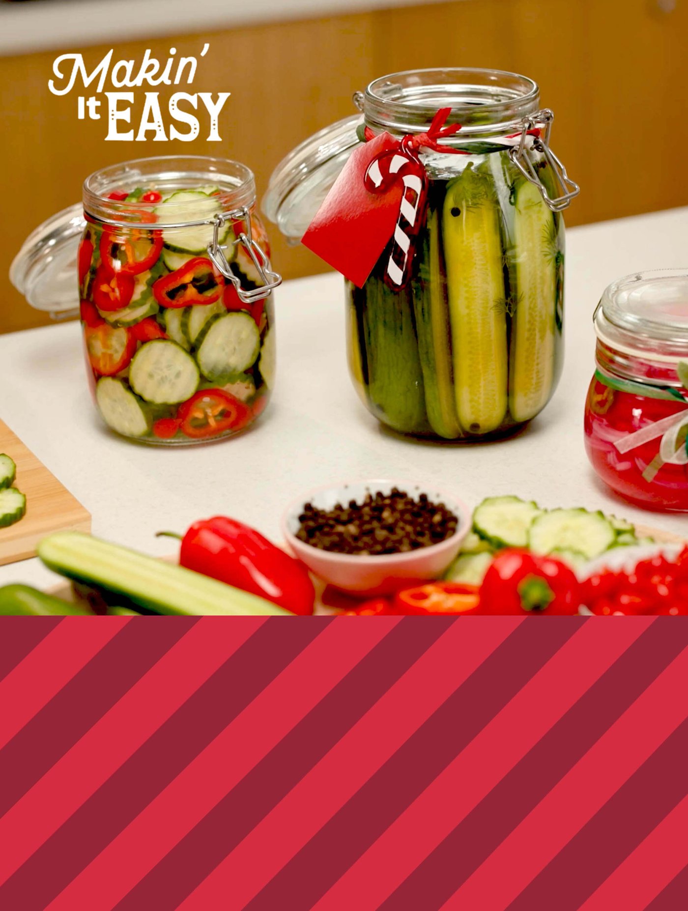 Jars of pickled cucumbers and peppers on a counter with spices and vegetables; text reads “Makin’ It EASY.”