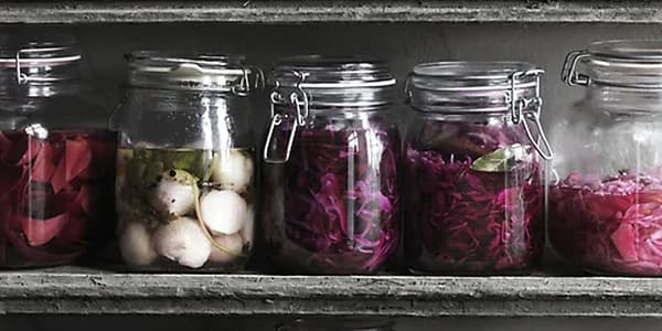Jars of pickles on shelves.