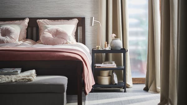 Jasna, schludnie urządzona sypialnia przygotowana na wiosnę z zasłonami zaciemniającymi BRITNA oraz łóżkiem IDANÄS z pościelą KRANSKRAGE.