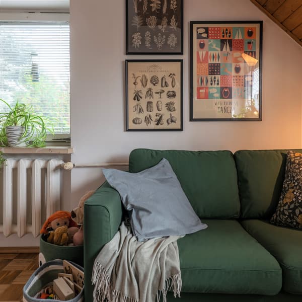 Jasnoniebieska poduszka dekoracyjna w poszewce SANELA leżaca na zielonej sofie PÄRUP.