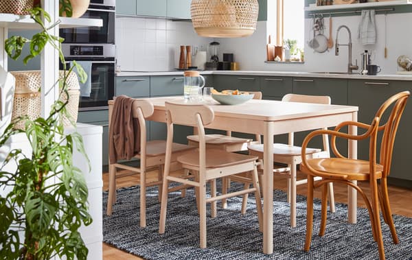 Jedálenský stôl z masívneho brezového dreva so štyrmi stoličkami zo série RÖNNINGE a stolička IKEA zo 60. rokov minulého storočia. 