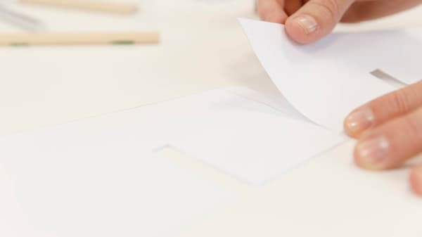 Jeman klebt die Papiervorlage zusammen.
