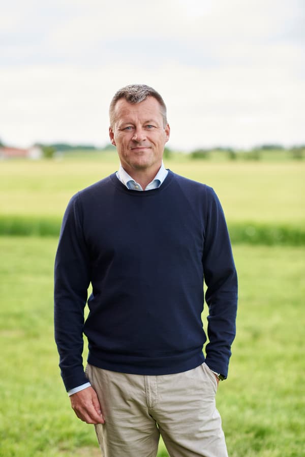 Jesper Brodin steht auf einem Feld im Grünen.