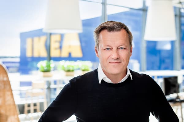 Jesper Brodin wearing a white shirt under a jumper in front of an IKEA store