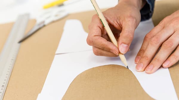 Jetzt zeichnet sie auf Karton dei Form des Kuchenständers mit einem Bleistift nach.