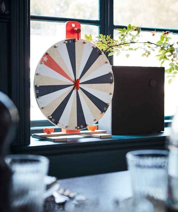 Jeu roue de fortune LUSTIGT et haut-parleur ENEBY sur le bord d’une fenêtre