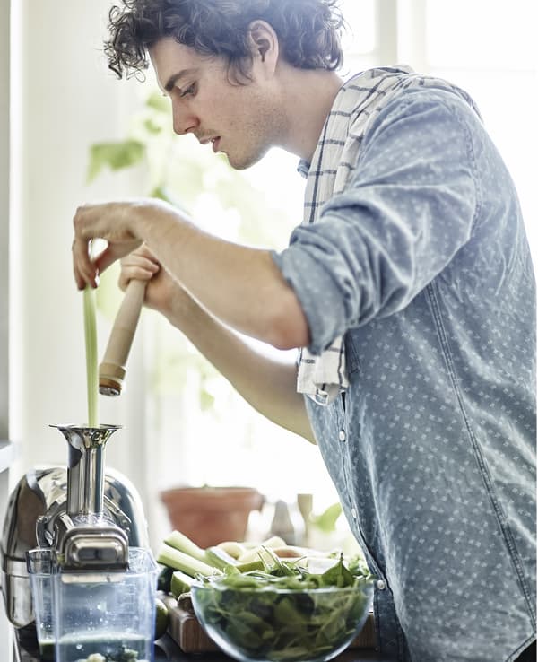 Jeune homme préparant un jus
